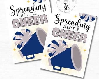 Puede incluir: Dos etiquetas imprimibles con un megáfono azul y pompones. El texto en las etiquetas dice "Spreading a little cheer". Las etiquetas miden 2,5 pulgadas por 3,5 pulgadas.
