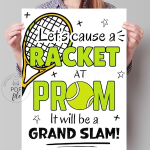 May include: A white printable sign with black text and illustrations. The text reads "Let's cause a racket at prom. It will be a grand slam!" The illustration is of a tennis racket and a tennis ball.