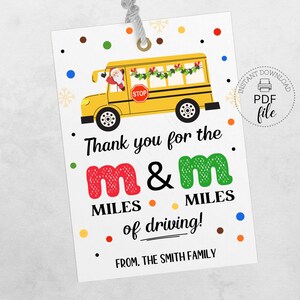 Pode incluir: Uma etiqueta branca com uma ilustração de ônibus escolar amarelo, Papai Noel e o texto "Thank you for the m&m miles of driving!" com bolinhas coloridas. Inclui um ícone de download de arquivo PDF.