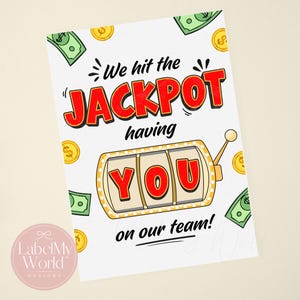 Może przedstawiać: Biała prostokątna kartka z napisem We hit the JACKPOT having YOU on our team! czarnymi i czerwonymi literami. Projekt zawiera centralną grafikę automatu do gry ze słowem YOU oraz rozrzucone zielone banknoty i złote monety.
