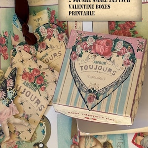 May include: A collection of Valentine's Day-themed paper crafts. The image features two small, square boxes, each measuring 3x3 inches, adorned with floral and heart designs. The boxes are accompanied by tags and cards with vintage-style illustrations and the text "Amour Toujours."