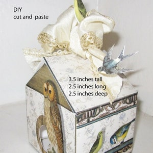 May include: A paper birdhouse home decor DIY project. The birdhouse is 3.5 inches tall, 2.5 inches long, and 2.5 inches deep. It features a white lace trim, a brown owl, and colorful birds.