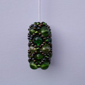 May include: A green and brown beaded light pull with a white cord. The beads are arranged in a geometric pattern.