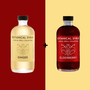 May include: Two glass bottles of botanical syrup with black caps. One bottle is filled with a light yellow liquid and labeled "Ginger." The other bottle contains a dark red liquid and is labeled "Elderberry."