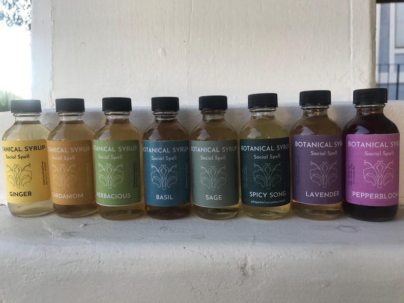 Natural ginger syrup bottle with black cap on pastel teal background; label reads Botanical Syrup Ginger