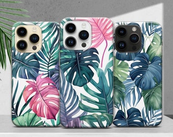May include: Three phone cases with a tropical leaf design. The cases are white with green, blue, and pink leaves. The phone cases are for an iPhone with a triple lens camera.