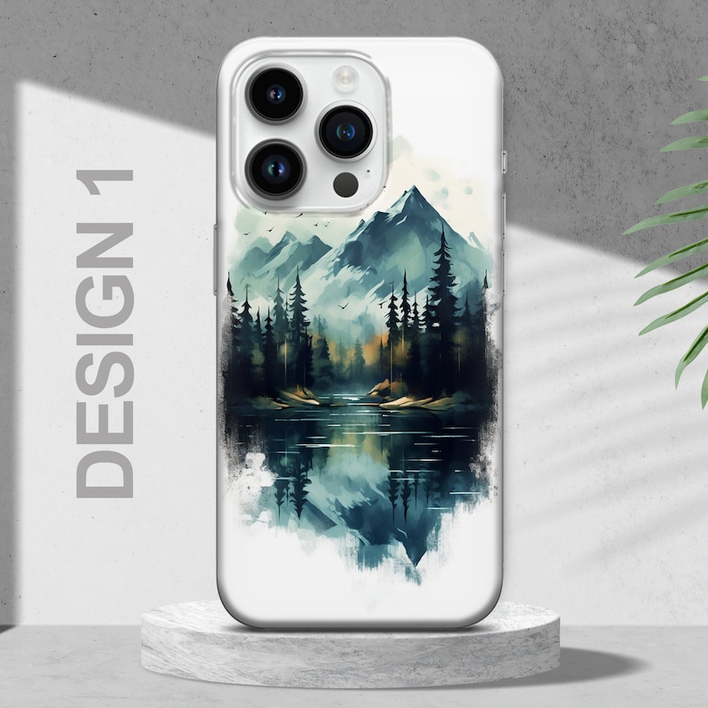 Puede incluir: Una funda de tel&eacute;fono blanca con un dise&ntilde;o de acuarela de una cordillera, un lago y &aacute;rboles. El dise&ntilde;o est&aacute; en tonos de azul, verde y marr&oacute;n.