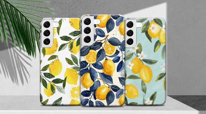 May include: Three phone cases with lemon designs. The first case has a white background with yellow lemons and green leaves. The second case has a white background with blue leaves and yellow lemons. The third case has a light blue background with yellow lemons and white flowers.