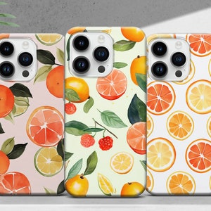 Könnte beinhalten: Drei iPhone-Hüllen mit verschiedenen Zitrusfrüchten-Designs. Die erste Hülle hat einen rosa Hintergrund mit Orangen, Grapefruits und Limetten. Die zweite Hülle hat einen grünen Hintergrund mit Orangen, Grapefruits, Zitronen und Himbeeren. Die dritte Hülle hat einen weißen Hintergrund mit orangefarbenen und gelben Zitrusscheiben.
