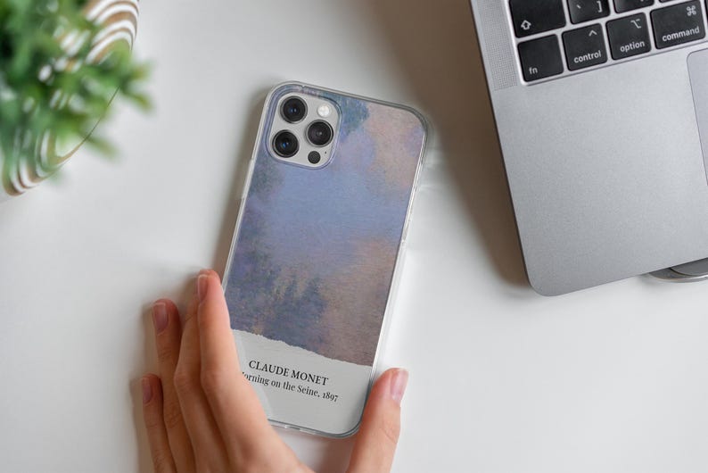 May include: A clear phone case with a watercolor-style design featuring a blue and purple sky. The case has a white label with the text "CLAUDE MONET,  Morning on the Seine, 1897".