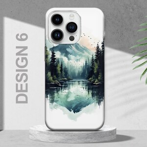 Puede incluir: Una funda de tel&eacute;fono blanca con un dise&ntilde;o de acuarela de un lago de monta&ntilde;a y un bosque. El dise&ntilde;o presenta un reflejo de la monta&ntilde;a y los &aacute;rboles en el agua.