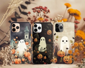 May include: Three smartphone cases featuring Halloween-themed illustrations. The left case shows a ghost and pumpkins near a tower. The center case depicts a ghost in a dark forest with pumpkins. The right case displays a ghost and pumpkins.