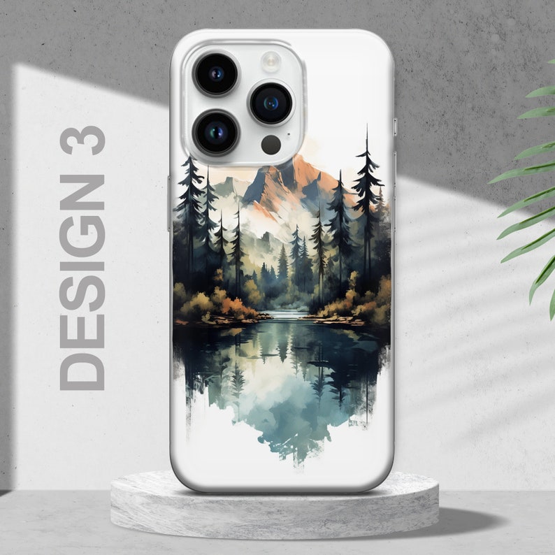 Puede incluir: Una funda de tel&eacute;fono blanca con un dise&ntilde;o de acuarela de una cordillera y un lago que refleja el agua. El dise&ntilde;o presenta un bosque de pinos y una cordillera en el fondo. La funda del tel&eacute;fono tiene una parte posterior transparente y un borde blanco.