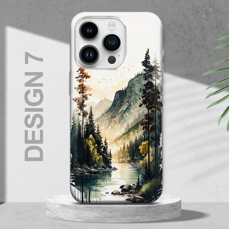 Puede incluir: Una funda blanca para iPhone con un dise&ntilde;o de acuarela de una cordillera, un r&iacute;o y &aacute;rboles. El dise&ntilde;o est&aacute; en tonos de verde, azul y marr&oacute;n.