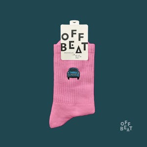 Könnte beinhalten: Rosa gerippte Socken mit einem blauen Auto auf der Vorderseite. Die Socken haben ein Etikett mit der Aufschrift "OFF BEAT" und "offbeat-berlin.com". Größe 41-46, unisex.