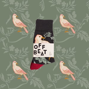 May include: A pair of black socks with a floral pattern and a pink bird design. The socks have a red cuff and the text "OFF BEAT" is printed on the front.