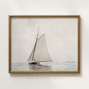 May include: A framed watercolor print depicting a sailboat with a white sail on a calm sea under a pale sky. The boat has a dark hull and a wooden mast. The frame is thin and metallic gold. The text MADAME ANTIQUE PRINTS is visible at the bottom.