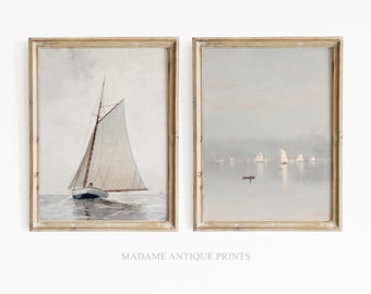 May include: Two framed vertical art prints featuring nautical scenes. The left print shows a single sailboat on water. The right print depicts a calm seascape with multiple distant sailboats and a small rowboat. Both prints are in gold frames.