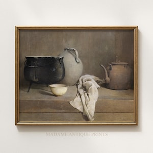 May include: A still life painting featuring a black cauldron, a white ceramic pitcher, a small bowl, and a brown teapot. A draped cloth rests on a wooden surface. The artwork is framed in a gold-colored frame.