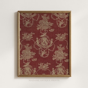 May include: A framed wall art print featuring a deep red background with a repeating beige toile pattern. The design displays intricate illustrations of cherubs, floral bouquets, and oval medallions, all enclosed in a thin, metallic gold frame.