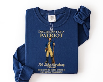 May include: True navy long-sleeve shirt with the text "DESCENDANT OF A PATRIOT" and an illustration of a soldier. The shirt also includes the text "Pvt. Luke Stansbury 1758-1848" and location details.
