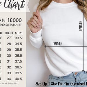 Puede incluir: Sudadera blanca Gildan 18000 de mezcla pesada con una tabla de tallas. La tabla muestra las medidas en pulgadas para el ancho, el largo y el largo de la manga. El texto aconseja subir una talla para un look oversize.