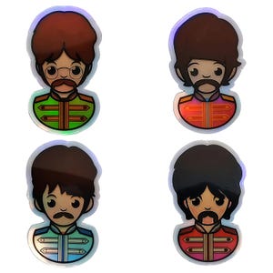 May include: Four holographic stickers depicting cartoon illustrations of men with different hairstyles and moustaches. Each figure is wearing a colourful military-style jacket. The stickers have a glossy, reflective finish against a white background.