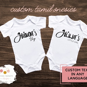 May include: Two white baby onesies with black text. One says "அம்மா'S Boy" and the other says "அப்பா'S LITTLE GIRL". The image also includes the text "custom tamil onesies" and "CUSTOM TEXT IN ANY LANGUAGE".