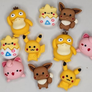 Puede incluir: Una colecci&oacute;n de figuras de personajes coloridos, incluyendo patos amarillos, Pikachu, Eevee marr&oacute;n y Jigglypuff rosa. Las figuras tienen detalles y est&aacute;n dispuestas sobre un fondo claro. Probablemente sean objetos de colecci&oacute;n.