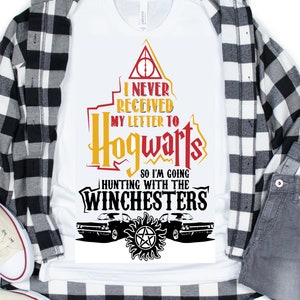 Puede incluir: Camiseta blanca con un diseño gráfico que presenta el escudo de Hogwarts y el texto "Nunca recibí mi carta a Hogwarts, así que voy a cazar con los Winchester". El gráfico también incluye una representación del coche icónico del programa de televisión Supernatural.