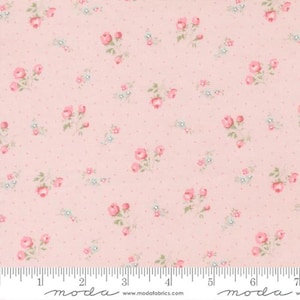 May include: Pink fabric with a repeating pattern of small pink roses and light blue flowers. The fabric has a dotted background and a ruler along the bottom edge. The fabric is from Moda Fabrics.