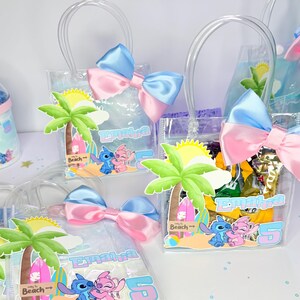 May include: Clear plastic gift bags with blue and pink satin bows. Each bag features a palm tree, the characters Stitch and Angel, and the name "Emalha". The bags are filled with treats and have clear handles.