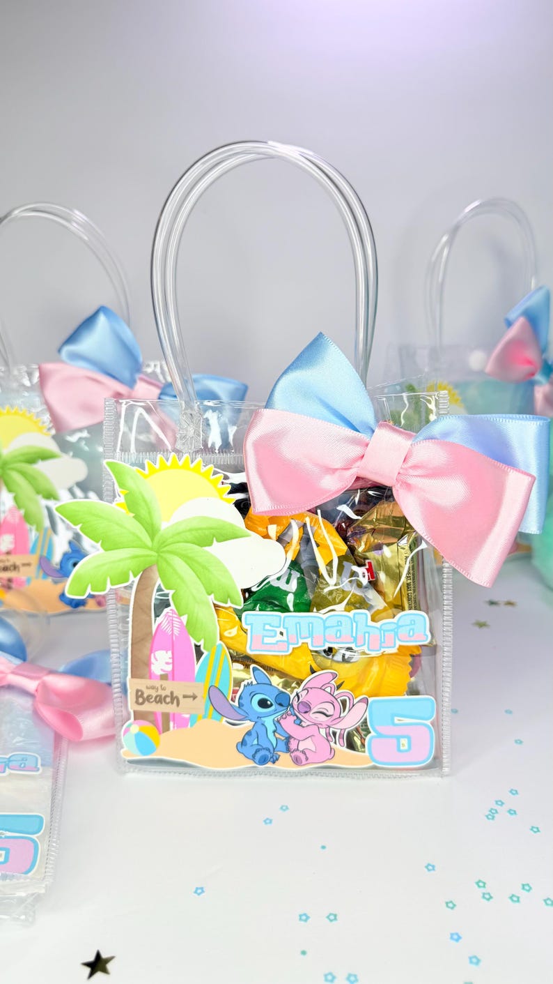 May include: Clear plastic gift bags filled with candy, each adorned with a blue and pink bow. The bags feature a beach-themed graphic with cartoon characters and the name "Emahra" and the number "5".