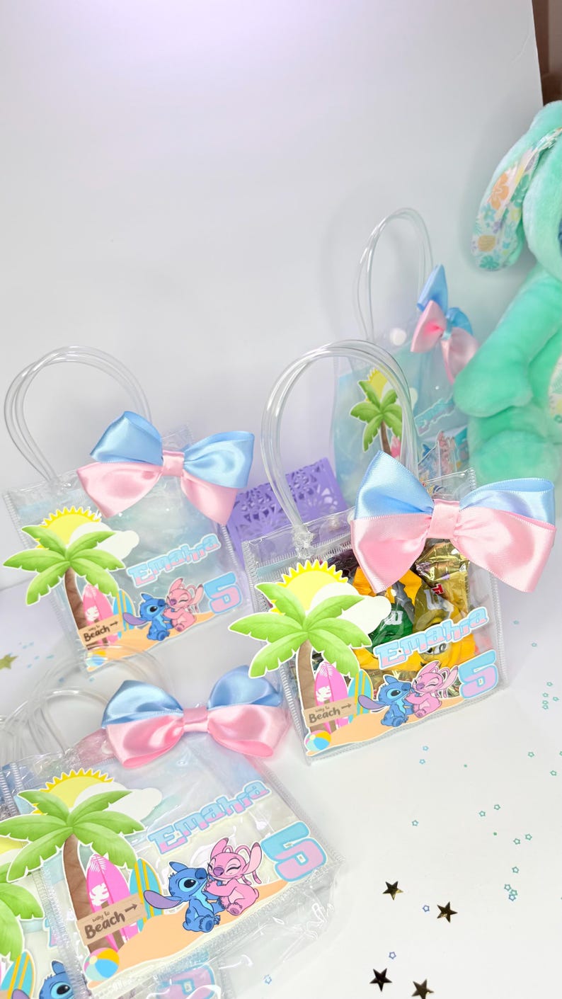 May include: Clear plastic tote bags with blue and pink satin bows. Each bag features a beach-themed graphic with cartoon characters, a palm tree, and the name "Emalra" with the number "5".