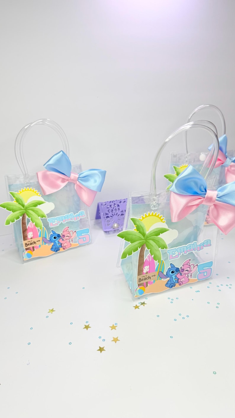May include: Clear plastic favor bags with blue and pink bows. Each bag features a beach scene with palm trees, Stitch and Angel characters, and the name "Emaira" with the number "5".