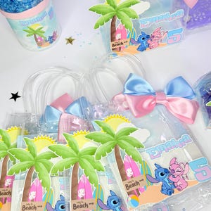 May include: Clear plastic favor bags with blue and pink satin bows. Each bag features a beach scene with palm trees, surfboards, and the characters Stitch and Angel. A matching snow globe is also visible.