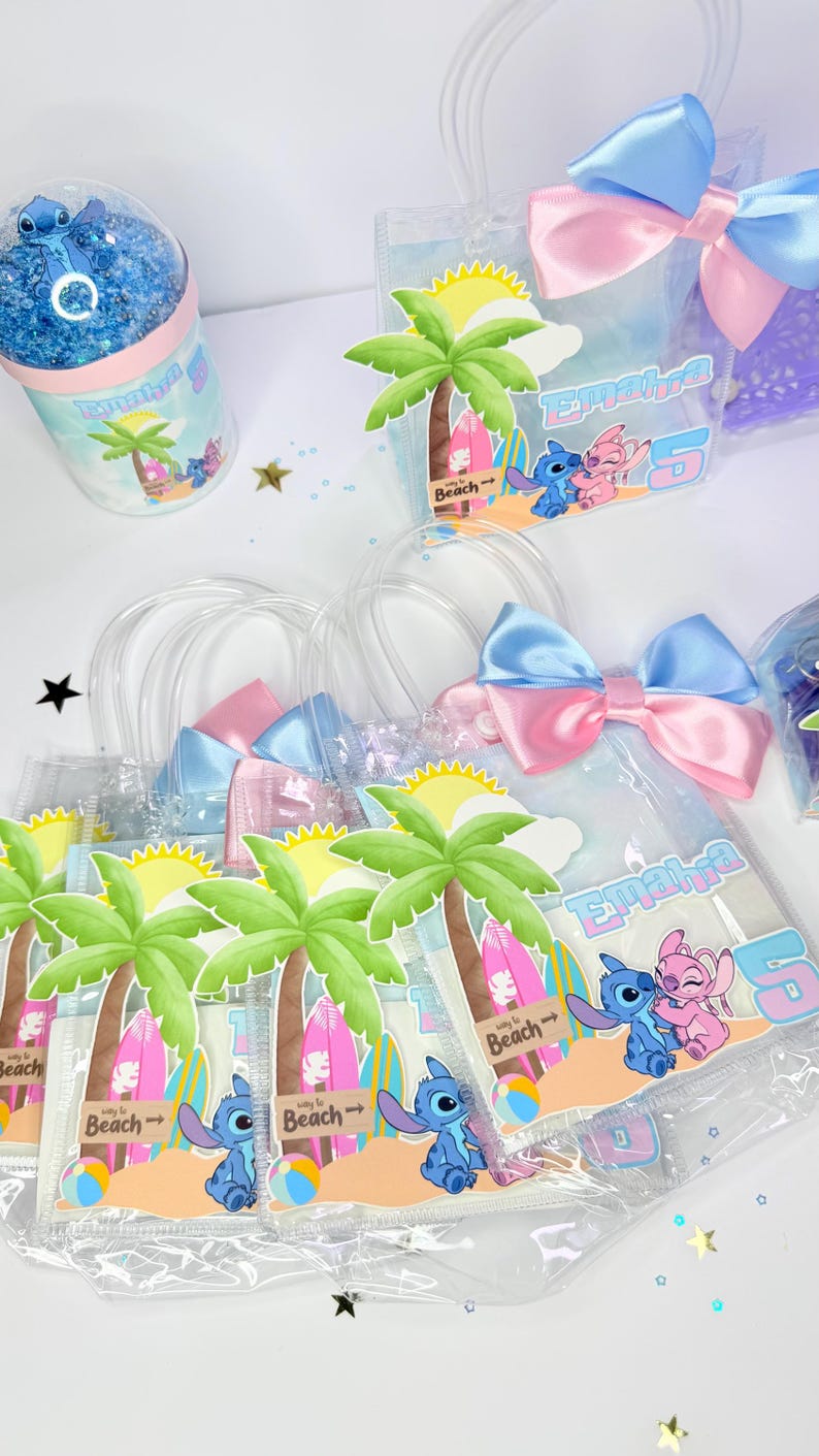 May include: Clear plastic favor bags with blue and pink satin bows. Each bag features a beach scene with palm trees, surfboards, and the characters Stitch and Angel. A matching snow globe is also visible.