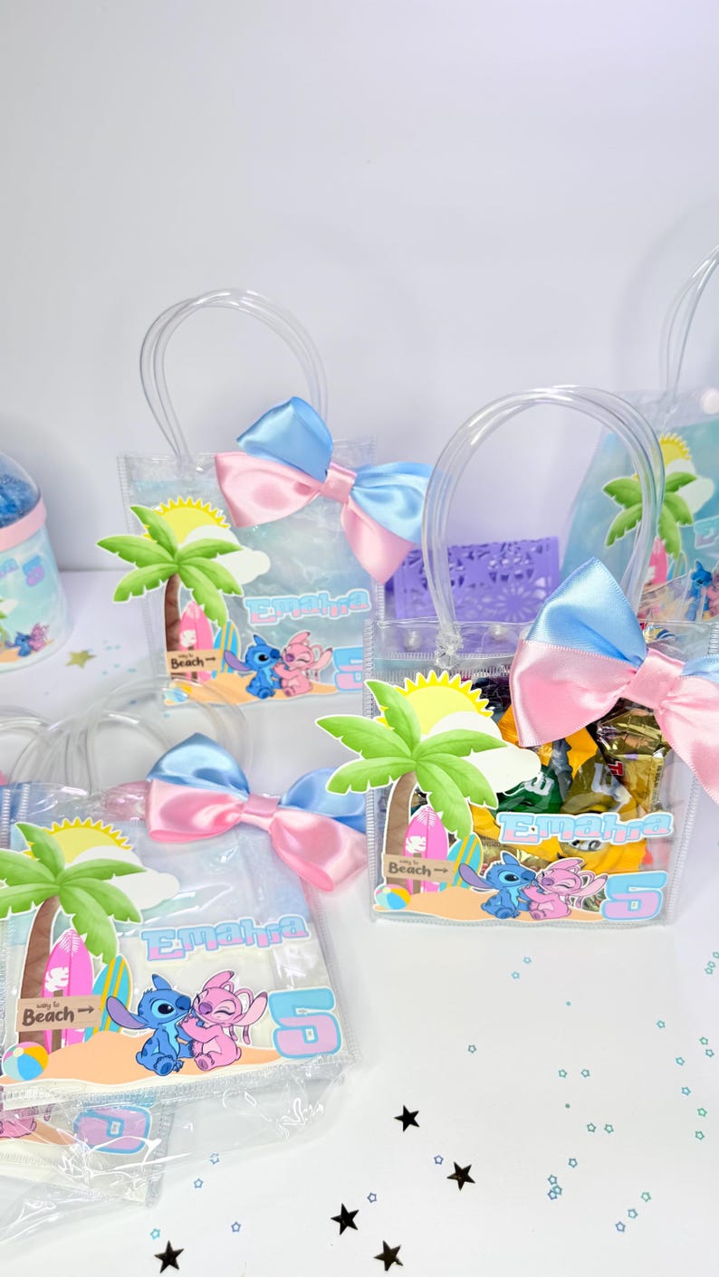 May include: Clear plastic favor bags with blue and pink bows. Each bag features a beach-themed graphic with cartoon characters, a palm tree, and the name "Emaira" with the number "5".