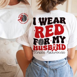 May include: White t-shirt with the text "I wear red for my husband Stroke Awareness" and a red ribbon. The back of the shirt has a red ribbon and brain graphic with the text "Support Squad Stroke Awareness".