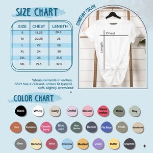 May include: A white t-shirt displayed on a wooden ladder, with a size chart and color chart. The size chart shows chest measurements from 18.25 to 27.5 inches and lengths from 26.6 to 32.5 inches. The color chart displays various colors.