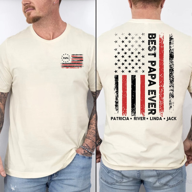 Puede incluir: Una camiseta de color crema con un dise&ntilde;o de bandera estadounidense desgastado en la espalda. La bandera tiene rayas rojas y negras con un dise&ntilde;o de estrella roja, blanca y azul en la esquina superior izquierda. El texto "BEST PAPA EVER" est&aacute; impreso verticalmente en el lado derecho de la bandera. Debajo de la bandera, el texto "PATRICIA * RIVER * LINDA * JACK" est&aacute; impreso. La parte delantera de la camiseta tiene un peque&ntilde;o dise&ntilde;o de bandera estadounidense desgastado con la palabra "PAPA" en el centro.