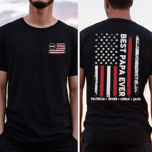 Puede incluir: Camiseta negra con un dise&ntilde;o de bandera americana desgastada en la parte delantera y trasera. El dise&ntilde;o de la parte trasera incluye el texto "Best Papa Ever" y los nombres "Patricia, River, Linda, Jack".