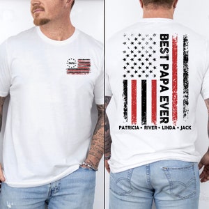 Puede incluir: Camiseta blanca con una peque&ntilde;a bandera americana con la palabra "Papa" en ella. La parte posterior de la camiseta tiene una gran bandera americana con las palabras "Best Papa Ever" y los nombres "Patricia, River, Linda, Jack" debajo.