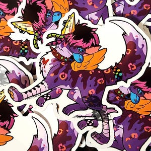 May include: A white ceramic mug with a black handle and the text "But First, Coffee" in a black, handwritten-style font. The mug is on a white surface.