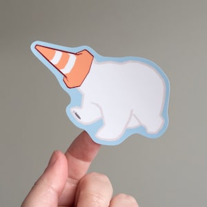 May include: A white polar bear sticker with an orange and white traffic cone on its head. The sticker is on a light blue background.