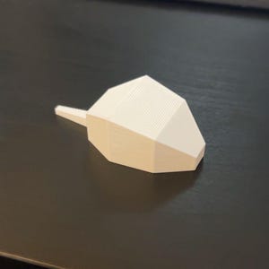 May include: White plastic 3D printed object with a pointed tip and a textured surface.