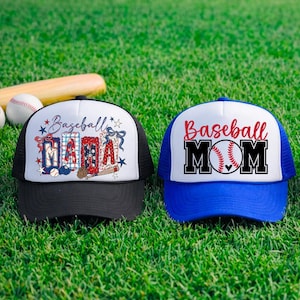 May include: Three baseball-themed trucker hats with white fronts and mesh backs. One hat is black, one is blue, and one is red. Each hat features the words "Baseball Mama" or "Baseball Mom" in various designs. A baseball bat and two baseballs are in the background.