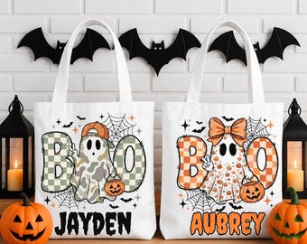 May include: Two white canvas tote bags featuring Halloween designs. The left bag shows a ghost wearing a cap with the text BOO and JAYDEN. The right bag shows a ghost with a bow with the text BOO and AUBREY. Both feature spiderwebs and pumpkins.