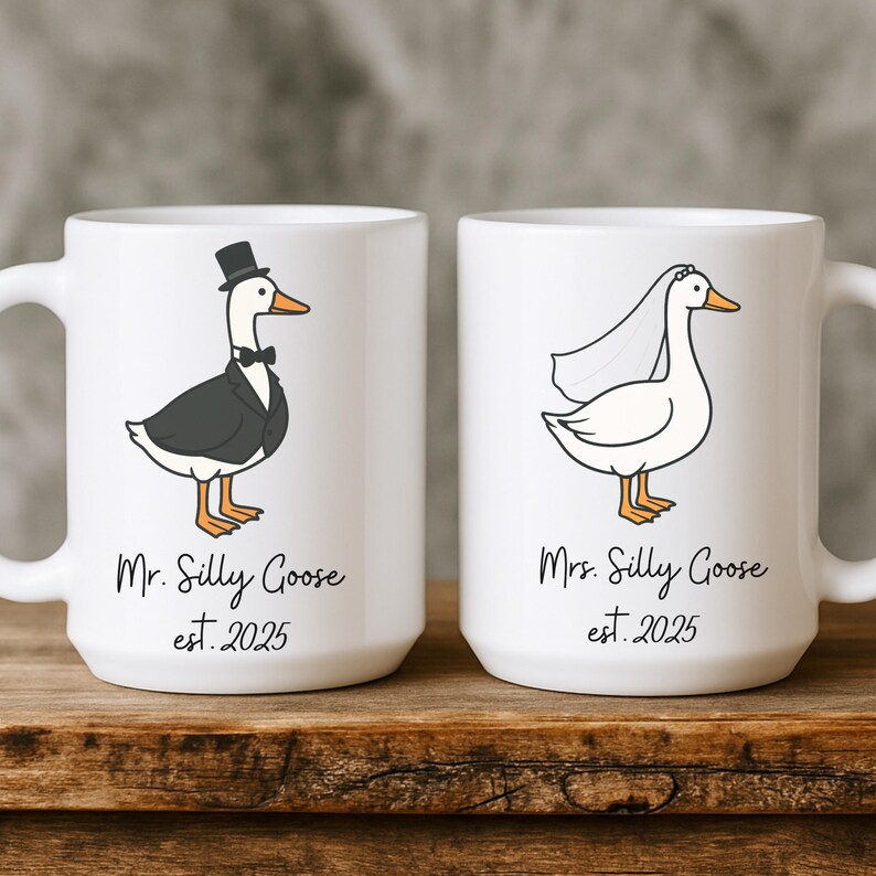 Puede incluir: Dos tazas de cer&aacute;mica blanca con una ilustraci&oacute;n de ganso de dibujos animados en cada una. La taza de la izquierda tiene un ganso con un esmoquin y un sombrero de copa con el texto "Mr. Silly Goose est. 2025". La taza de la derecha tiene un ganso con un velo con el texto "Mrs. Silly Goose est. 2025".