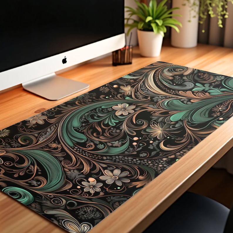 May include: A black desk mat with a green and gold floral pattern. The mat is on a wooden desk.